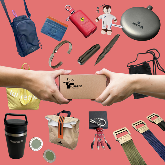 Hands exchanging a kraft surprise box surrounded by men’s accessories including designer keychains, travel mugs, wallets, and branded gear on a coral background. #SurpriseSetForHim #MensGiftBox #DesignerEssentials #LuxuryGiftIdeas #CuratedForHim #MensAccessories #MysteryBoxMen #StylishSurprise #PremiumGifting #MensLifestyleKit